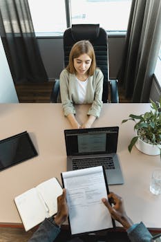 High-angle view of a job interview in a modern office setting, capturing professionalism.